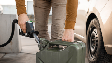 Ein Mann füllt Kraftstoff in einen Kanister.