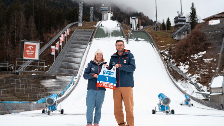 Skisprungweltmeisterin Katharina Schmid und Florian Stern, Geschäftsführer der
Skiclub Veranstaltungs GmbH und Leiter des OK für das Springen in Oberstdorf, präsentieren das Startnummerntrikot der 2-Nights-Tour in der Orlen Arena Oberstdorf.