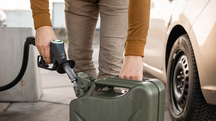 Ein Mann füllt Kraftstoff in einen Kanister.