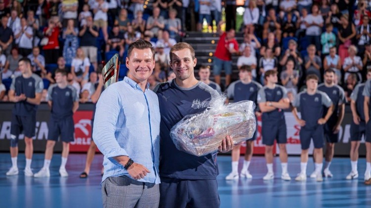 Orlen Deutschland CEO Jarosław Marczak (l.) 
überreicht den Siegerpokal an HSV Handball-Kapitän Niklas Weller.