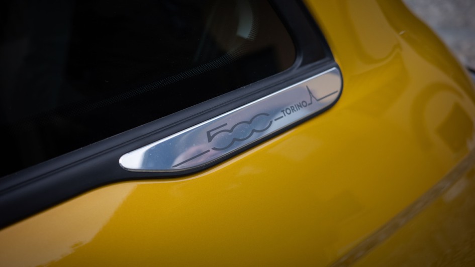 Schriftzug "Torino" des Sondermodells des Fiat 500 auf einem Aluemblem an der unteren Fensterleiste des Fiat 500 Hybrid